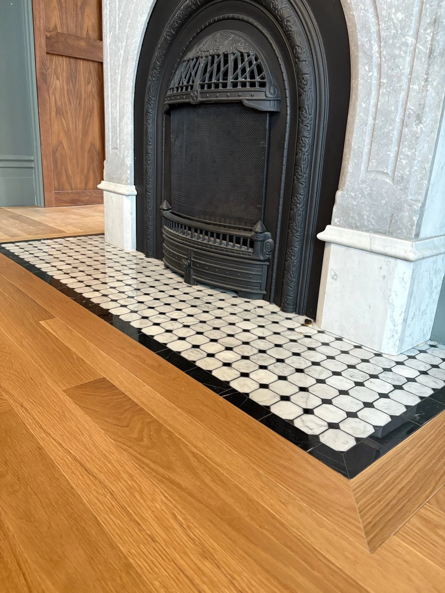Close detail of the living room fireplace hearth and wood floor inlay
