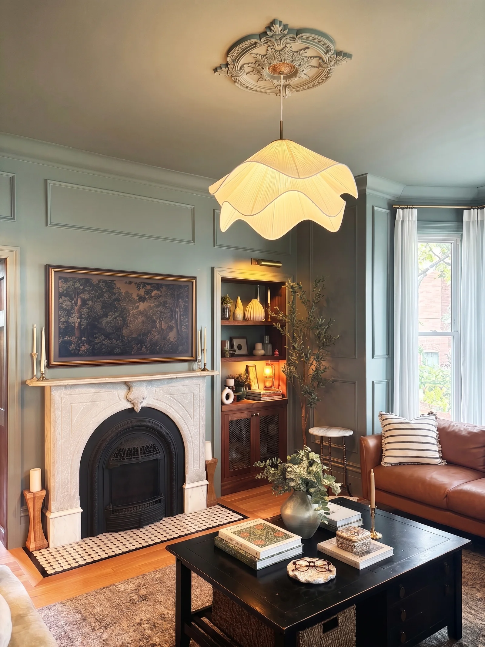 Living room fireplace with pendant shade, ceiling medallion, and leather sofa