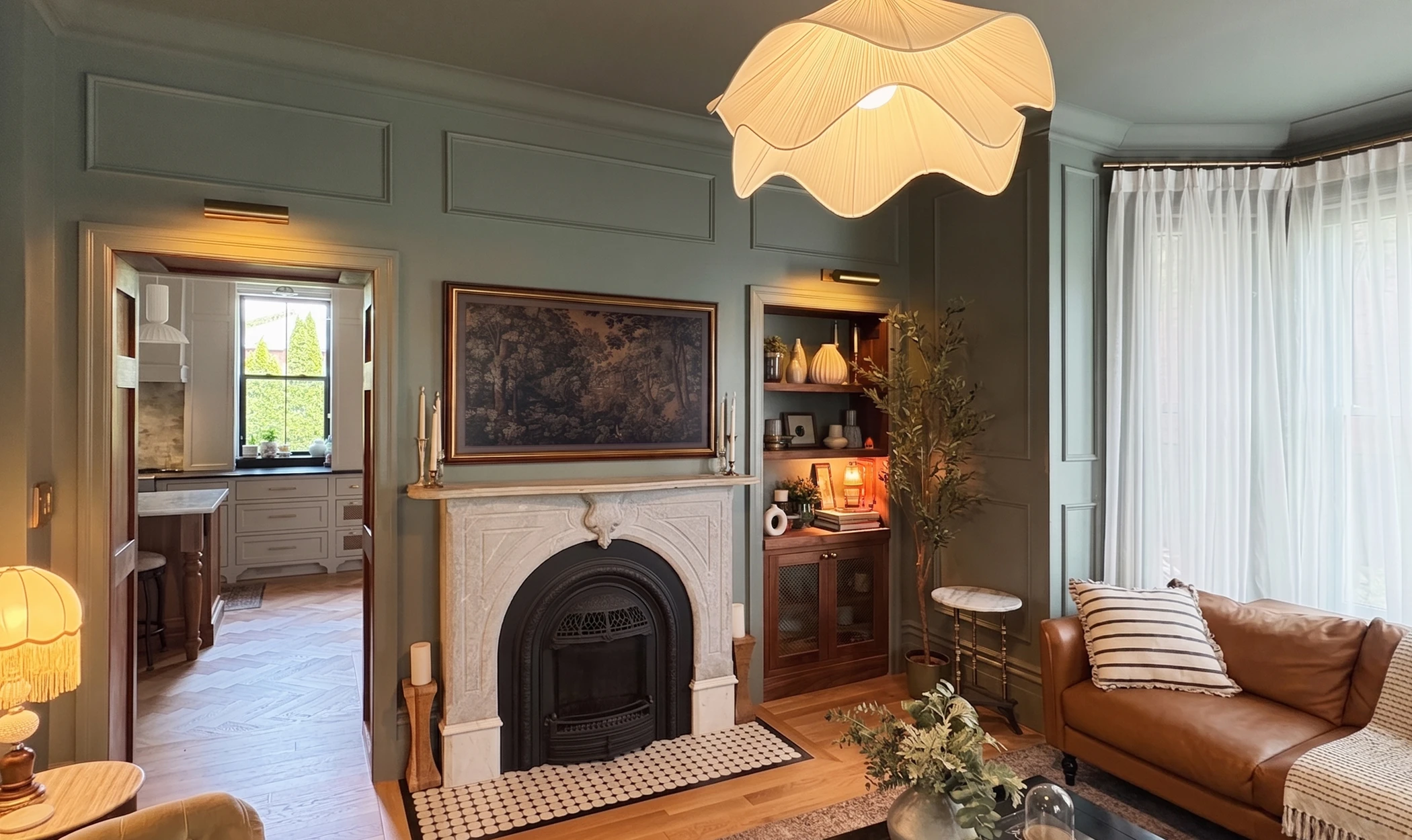 Layered living room view into a warm kitchen with historic trim and collected detail