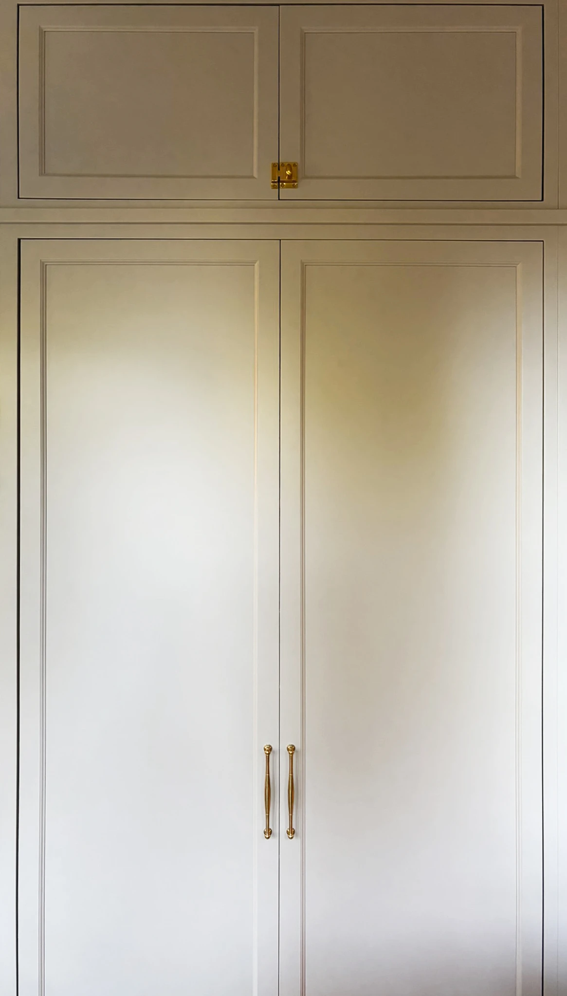 Closed paneled hidden appliance cabinet with brass pulls